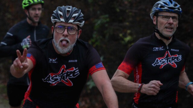 Participants lors d’une course de triathlon en forêt, portant maillots et casques, montrant leur esprit d’équipe et leur passion pour le sport. Triathlons, compétition, course endurance, équipe triathlon, sport outdoor, entraînement triathlon.